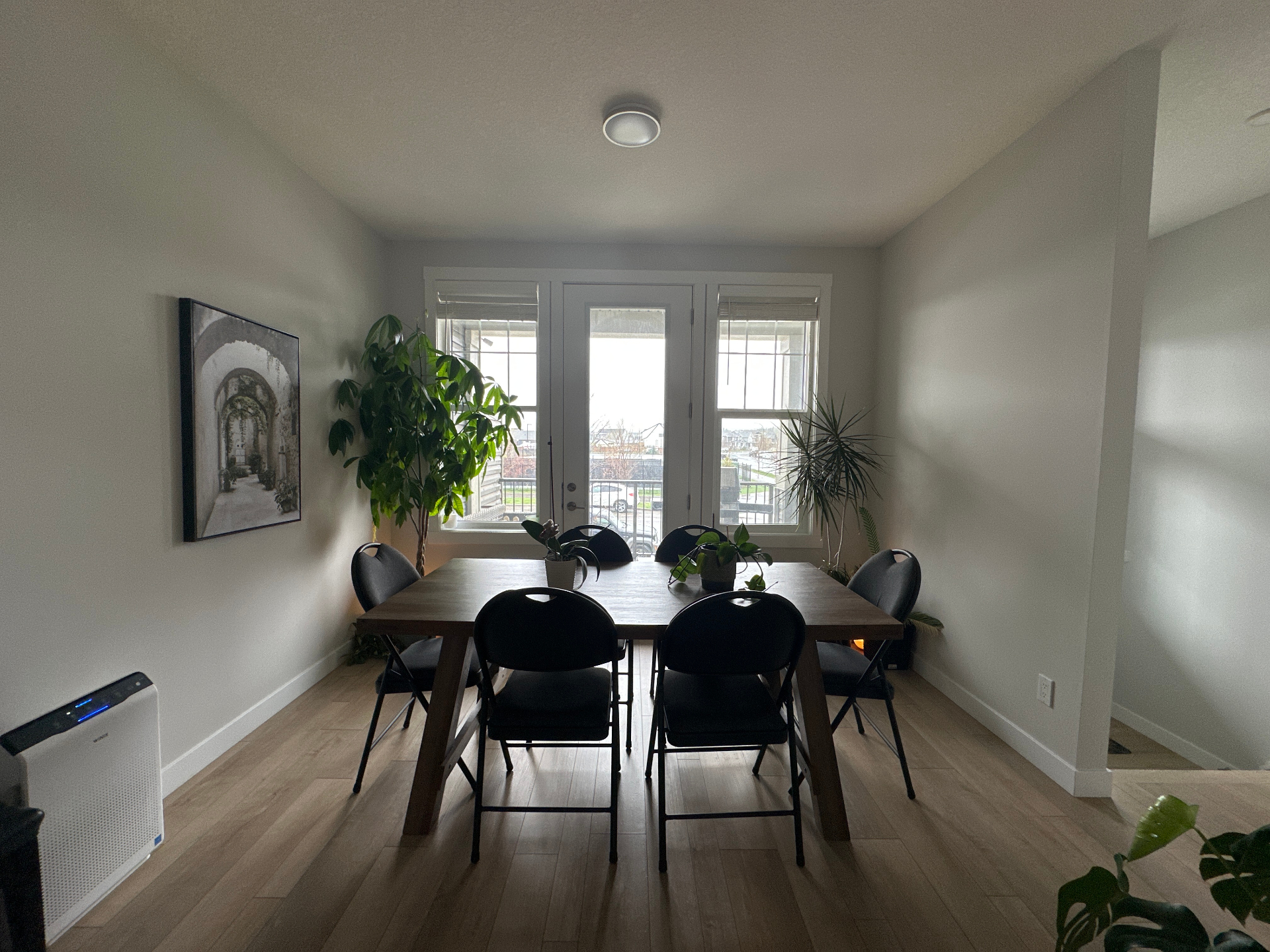 Original phone photo of a dim dining room with folding chairs and an air purifier